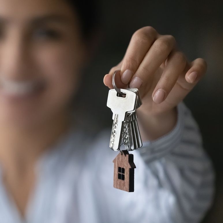 Vrouw met de sleutels om een huis te verhuren.
